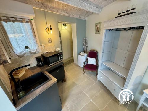 a kitchen with a microwave and a refrigerator at La cazabanelle in Villegly
