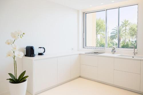 a white kitchen with a sink and a window at Bianco d'Alghero - apartment by the sea in Alghero