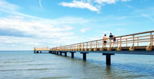 two people walking on a pier over the water at Wonderful summer place in beautiful Köpingsvik, Borgholm in Köpingsvik