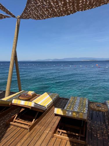 a deck with a table and chairs on the water at Swissôtel Living Bodrum in Bodrum City