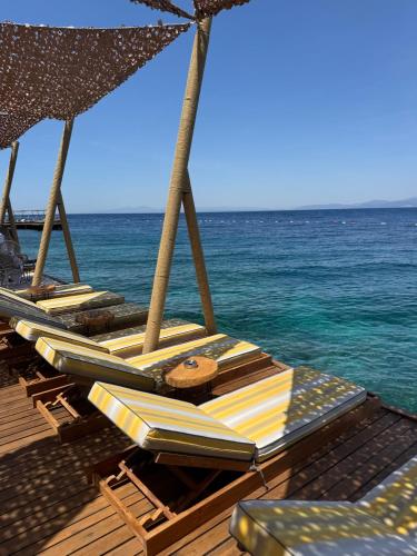 a group of chairs and umbrellas on a beach at Swissôtel Living Bodrum in Bodrum City