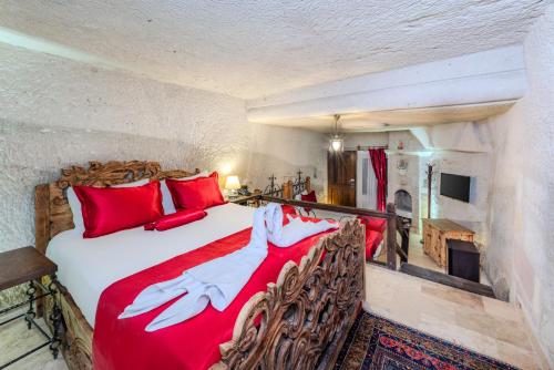 a bedroom with a large bed with red pillows at Onur Cave Cappadocia in Goreme