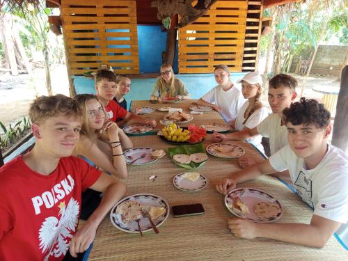 a group of people sitting around a table eating food at Sigiri Hunter's Eco Tree lodge in Sigiriya