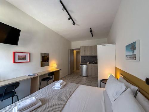 a bedroom with a bed and a desk and a kitchen at Seagull apartments - Building A in Paralia Katerinis