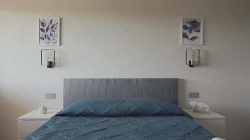 a bedroom with a bed and two pictures on the wall at Mhometredici Guest House in Sestu
