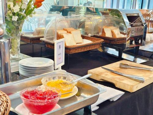 a buffet with a tray of bread and baskets of food at Buritel Hotel in Buriram