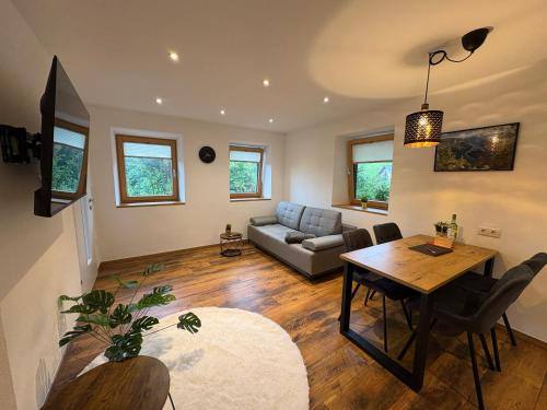 a living room with a table and a couch at Modernes Serviced Apartment - FeWo Land Idyll in Dürrnberg