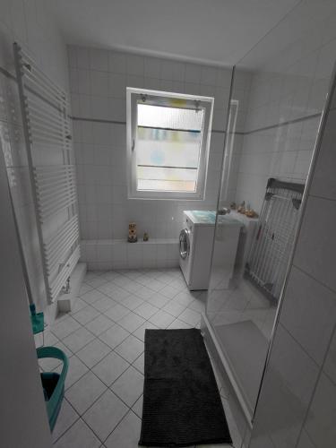 baño blanco con ducha y ventana en RiGa, en Gera