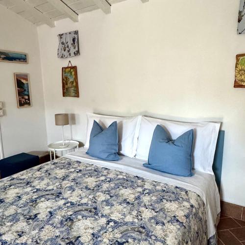 a bedroom with a large bed with blue pillows at Appartamento Cà Insulae in Luni
