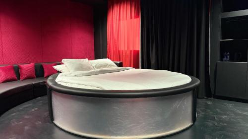 a circular bed in a room with pink walls at Royal Tulip Dancenter Suites Sharjah in Sharjah
