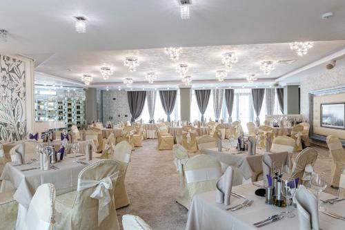 a banquet hall with white tables and chairs at Spa Hotel Persenk in Devin