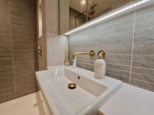 a white bathroom with a sink and a mirror at Wembley Cozy Cloud Waterfront Retreat with Parking near Wembley stadium in London