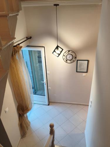 a hallway with a door and a clock on the wall at V House Cozy & Quiet Escape in Mytilene