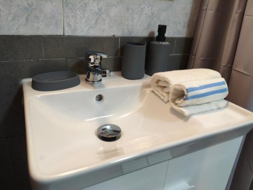 a bathroom sink with a towel and a faucet at V House Cozy & Quiet Escape in Mytilini