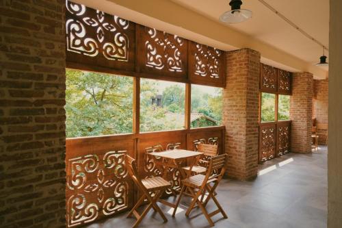 a dining room with a table and chairs and windows at Nekresi Estate in Kvareli