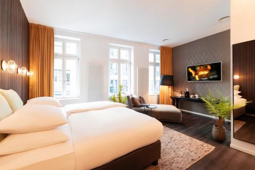 ブレーメンにあるNena Hotel Bremenの大きな白いベッドとソファのある寝室