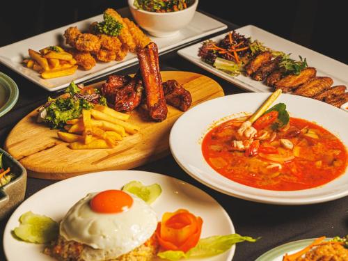 a table full of plates of food with different foods at CHECK inn Phnom Penh Royal Palace in Phnom Penh