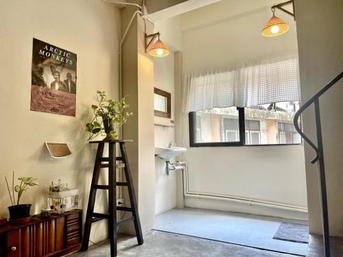 a room with a ladder and a window with a poster at Baan KhaoSoi - Rooftop House in Talad Noi in Samphanthawong