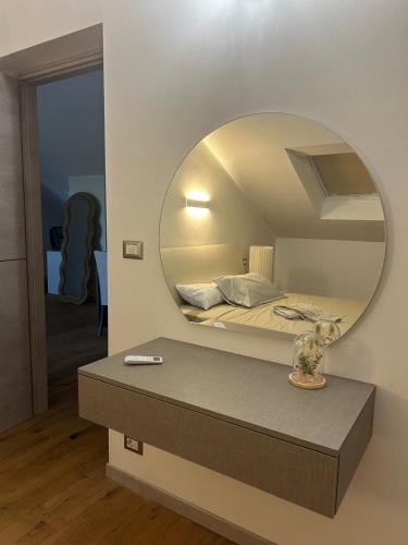 Habitación con cama y espejo en la pared. en Maison di Pino, en Pino Torinese