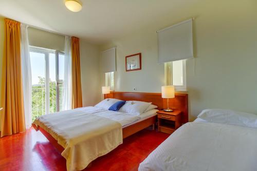 a hotel room with two beds and a window at Hotel Manora in Nerezine