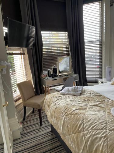 a bedroom with a bed and a desk with a computer at The Mowbray in Eastbourne