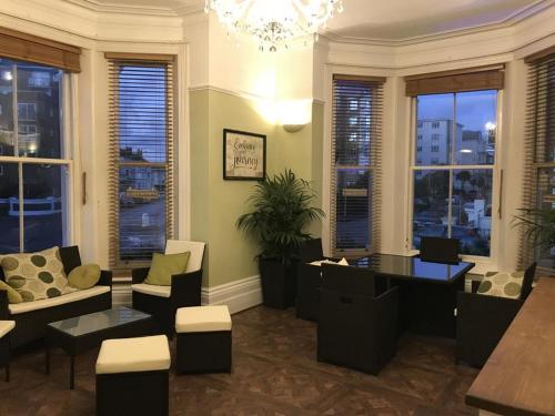 a living room with couches and a chandelier at The Mowbray in Eastbourne