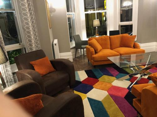 a living room with chairs and a glass table at The Mowbray in Eastbourne