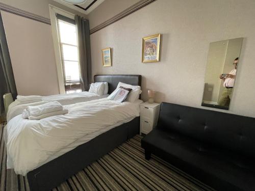 a bedroom with two beds and a mirror and a person taking a picture at The Mowbray in Eastbourne