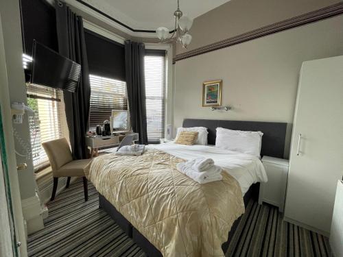 a bedroom with a large bed and a chair at The Mowbray in Eastbourne