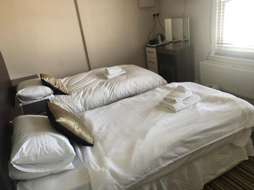 two beds in a room with towels on them at The Mowbray in Eastbourne