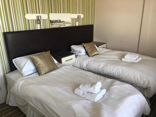 a hotel room with two beds with towels on them at The Mowbray in Eastbourne