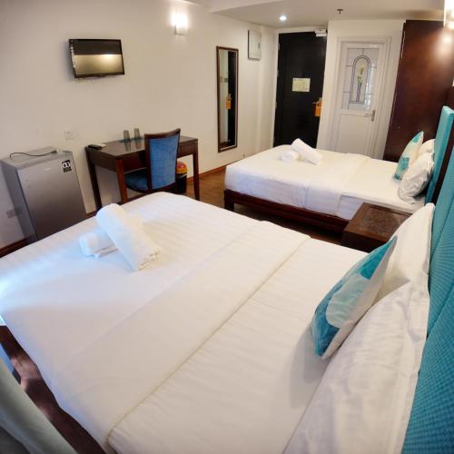a hotel room with two beds and a table at El Puerto Boracay in Boracay