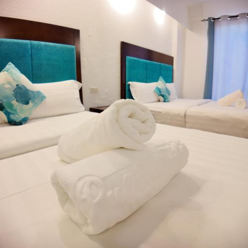 a room with two beds with towels on the floor at El Puerto Boracay in Boracay