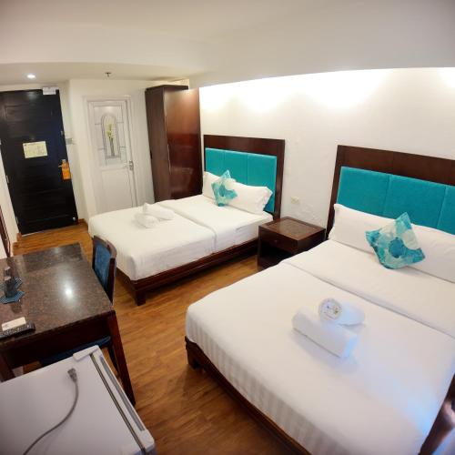 a hotel room with two beds and a table at El Puerto Boracay in Boracay