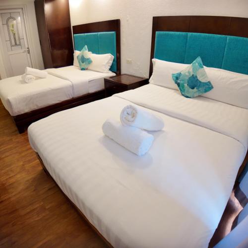 a hotel room with two beds with towels on them at El Puerto Boracay in Boracay