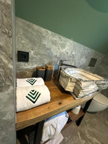 a bathroom with a table with towels and a toilet at Greenkova in Kamenitsa