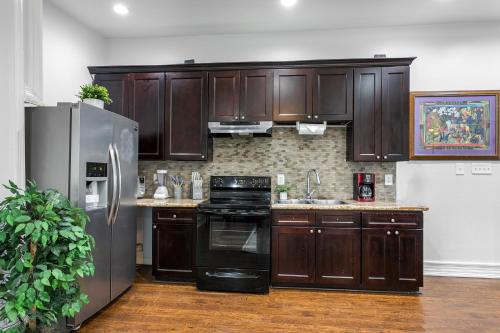 a kitchen with wooden cabinets and a stainless steel refrigerator at Modern 4BR Elegant Living - Downtown NOLA in New Orleans