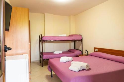 two beds in a room with purple sheets at Hotel Palinuro Cilentiamoci rooms in Palinuro