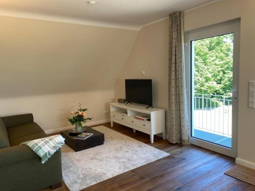 Una sala de estar con un sofá y un televisor. en Baumberger Blick, en Nottuln