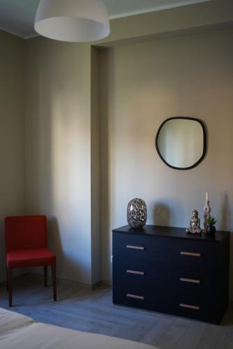 a bedroom with a red chair and a mirror at Tiber Domus Fiumicino - Apt 4 in Fiumicino