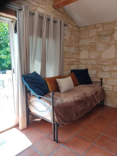 un lit assis dans une pièce à côté d'une fenêtre dans l'établissement Ardèche les cigales, studio laurier, à Grospierres