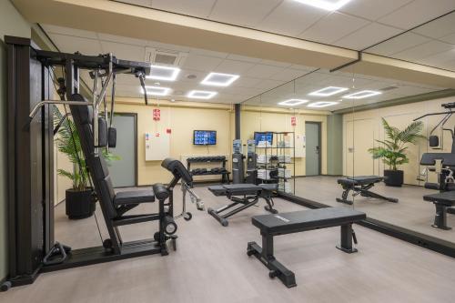 a gym with several treadmills and exercise bikes at Leonardo Hotel Breda City Center in Breda