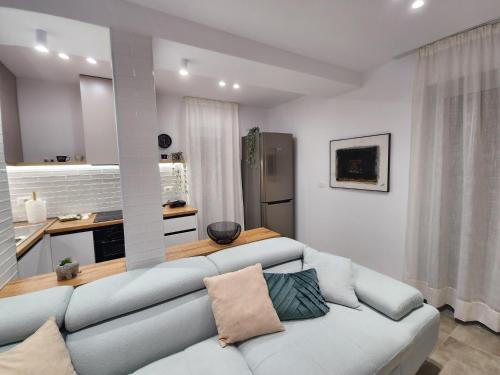 a living room with a couch and a kitchen at Feel like home 2 in Shkodër