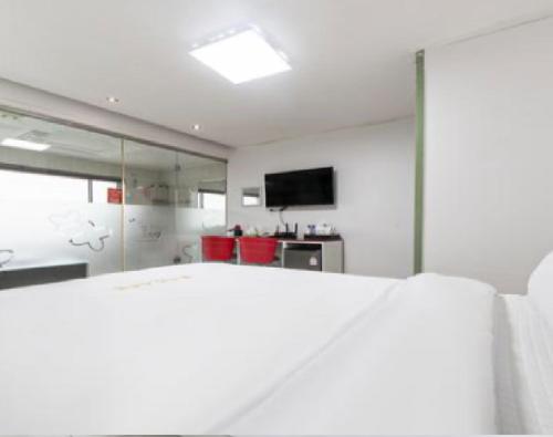a white room with a bed and a television at Star Spa Hotel in Haenam