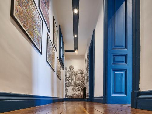 un couloir avec une porte bleue et des photos sur les murs dans l'établissement Appartement rénové T4 avec parking, Bayonne centre historique - FR-1-783-46, à Bayonne
