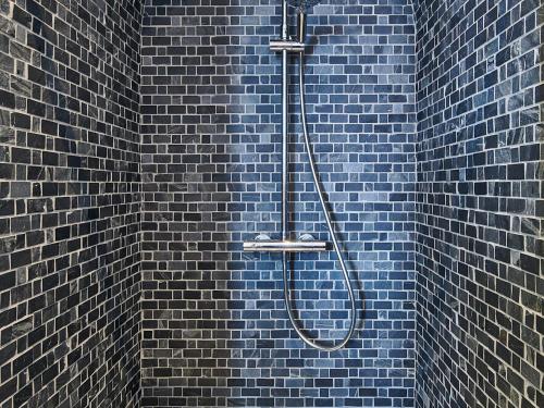une douche bleue dans un mur en briques bleues dans l'établissement Appartement rénové T4 avec parking, Bayonne centre historique - FR-1-783-46, à Bayonne
