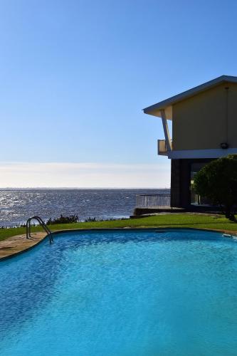 a large blue swimming pool next to the ocean at Pousada da Ria in Torreira