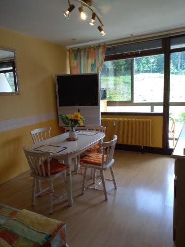 Una sala de estar con una mesa y sillas y un televisor. en Mon Petit Canada, en Mittlach