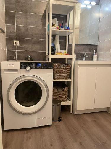 a washer and dryer in a room with a bathroom at Appartement plein centre à 50m de la plage in Soulac-sur-Mer