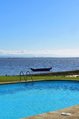 a swimming pool with a boat in the water at Pousada da Ria in Torreira